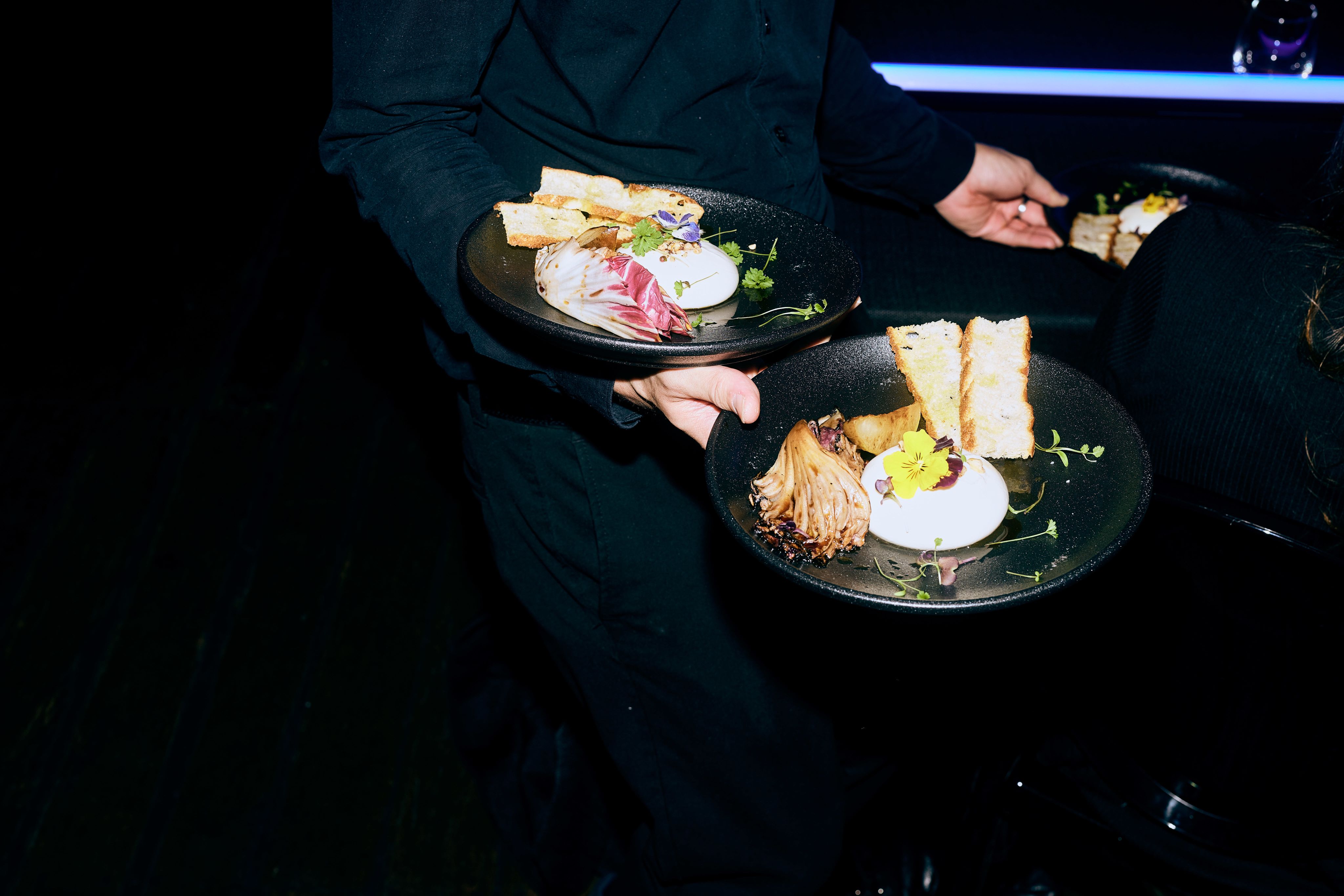 A waiter is carrying plates.