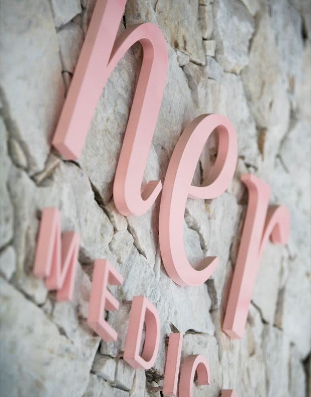 Pink signage which reads "her medical"