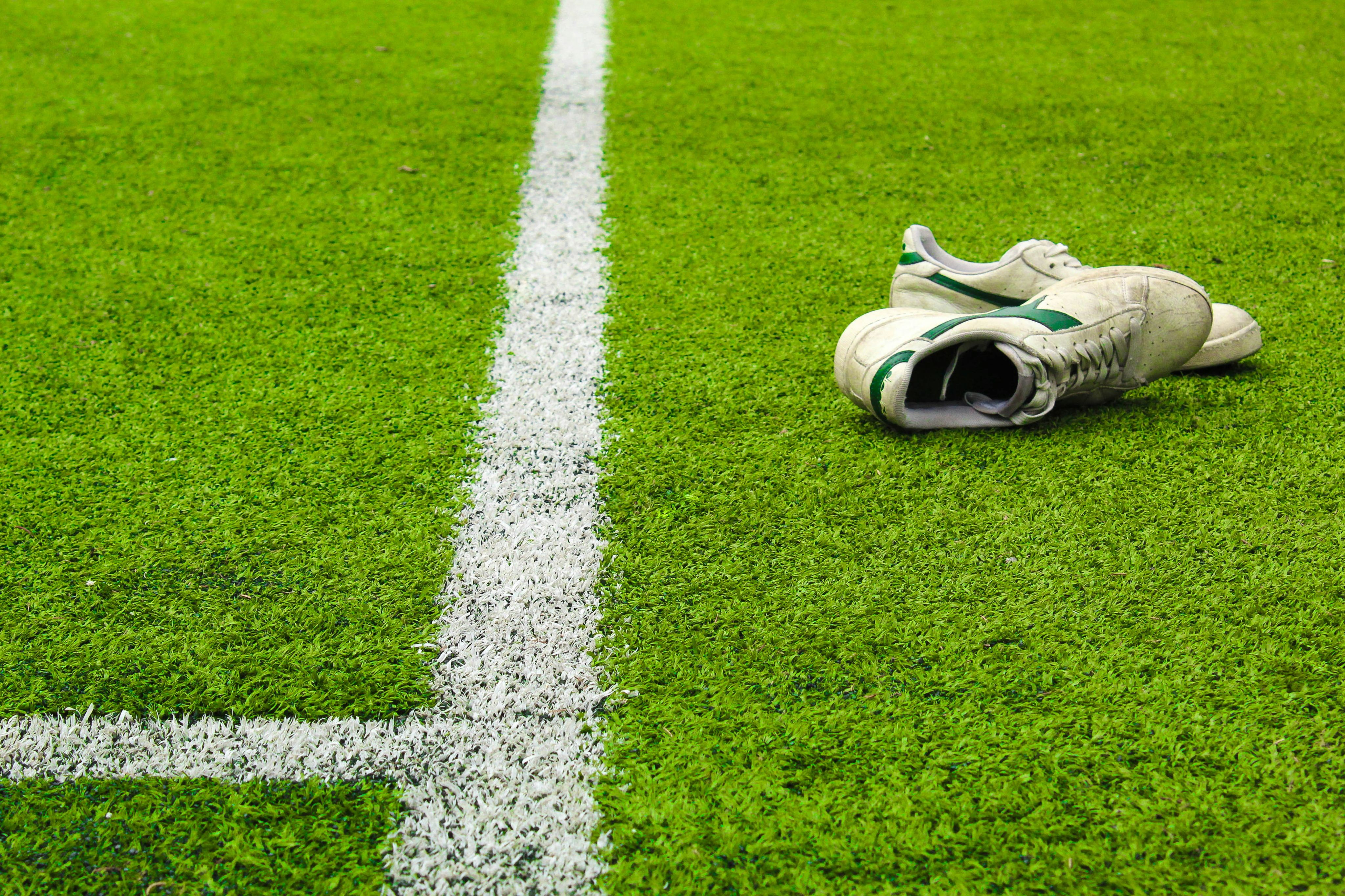 white and red nike sneakers on green grass field