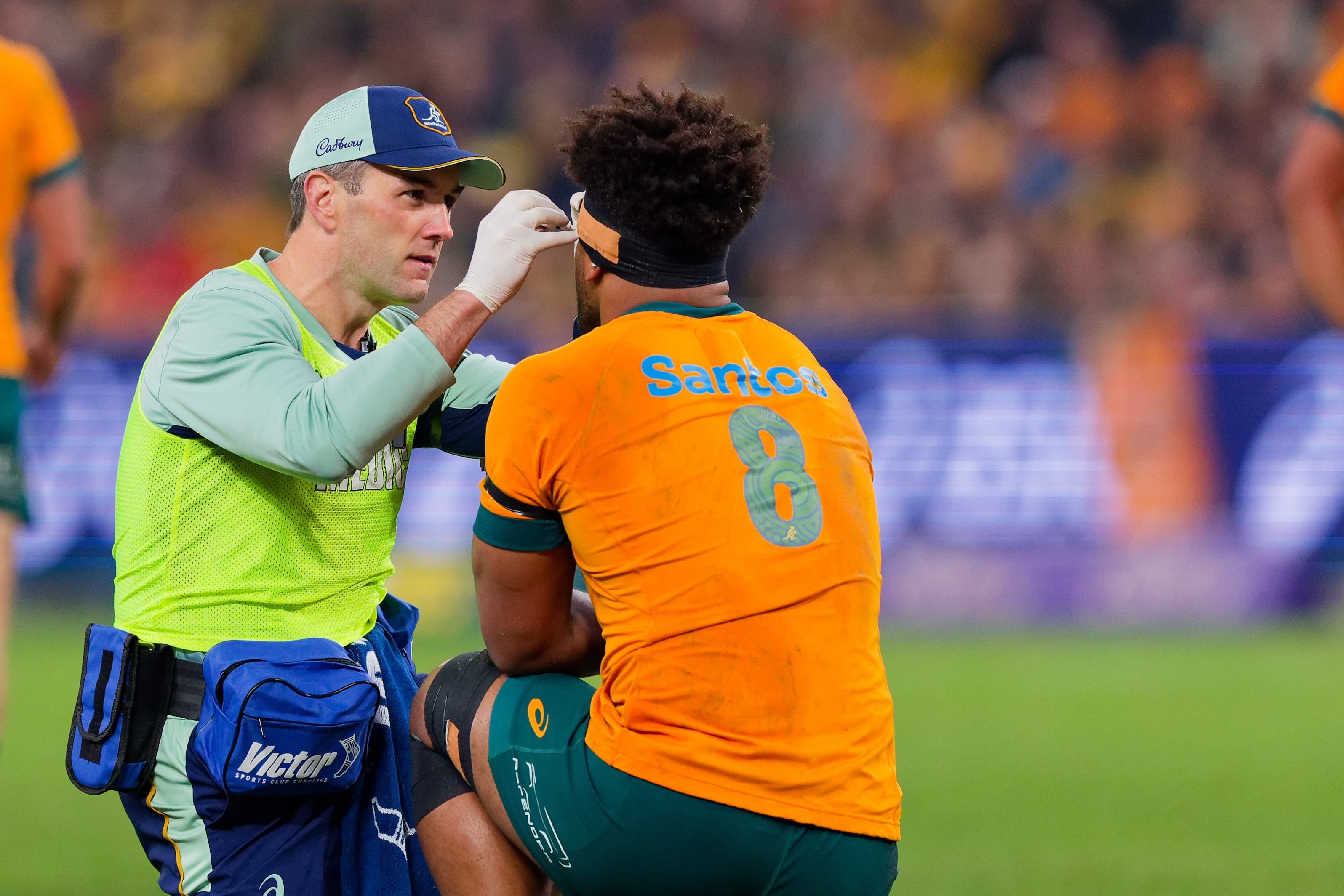 A rugby player receiving medical assistance on a field.