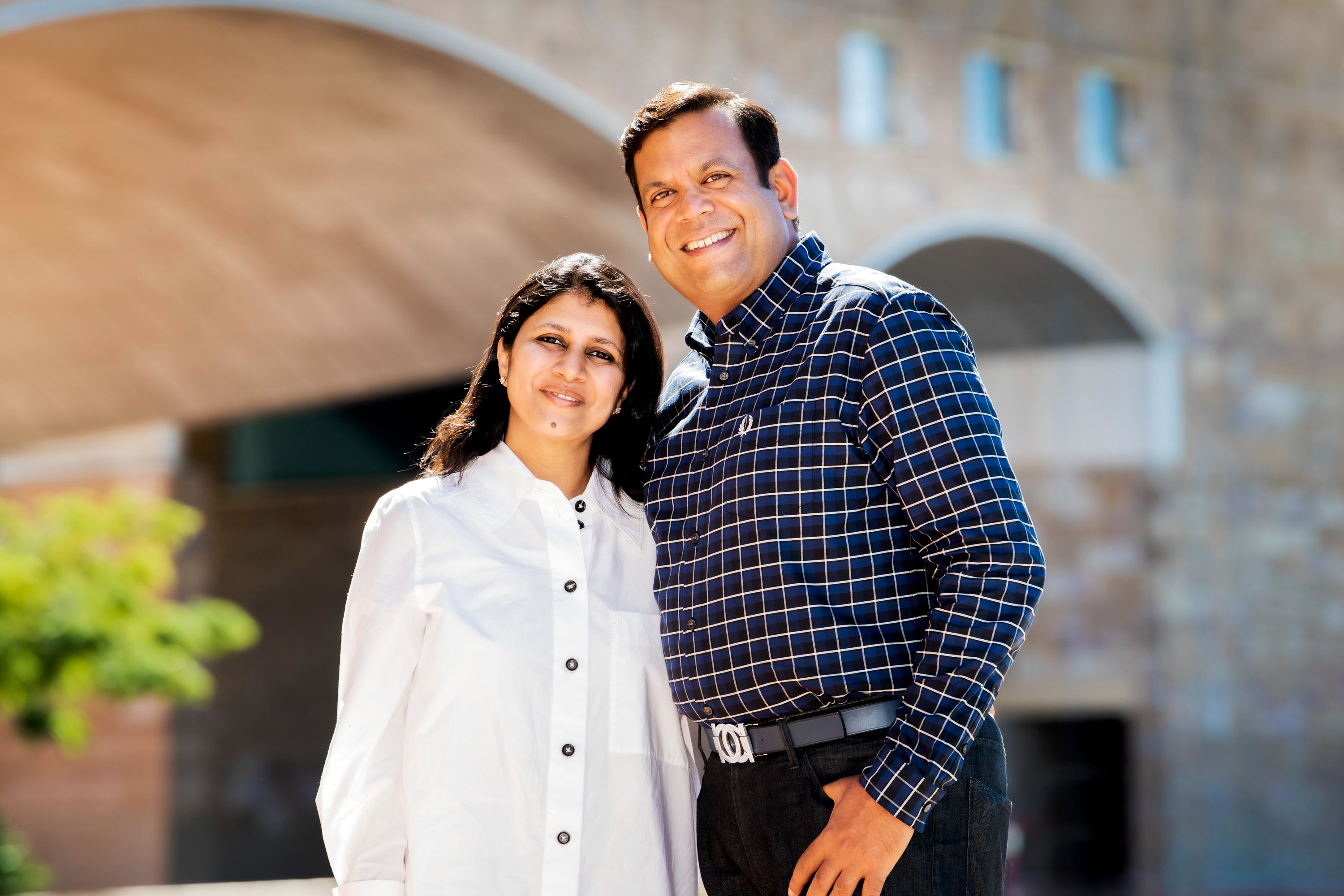 A man and a woman posing together, smiling. 