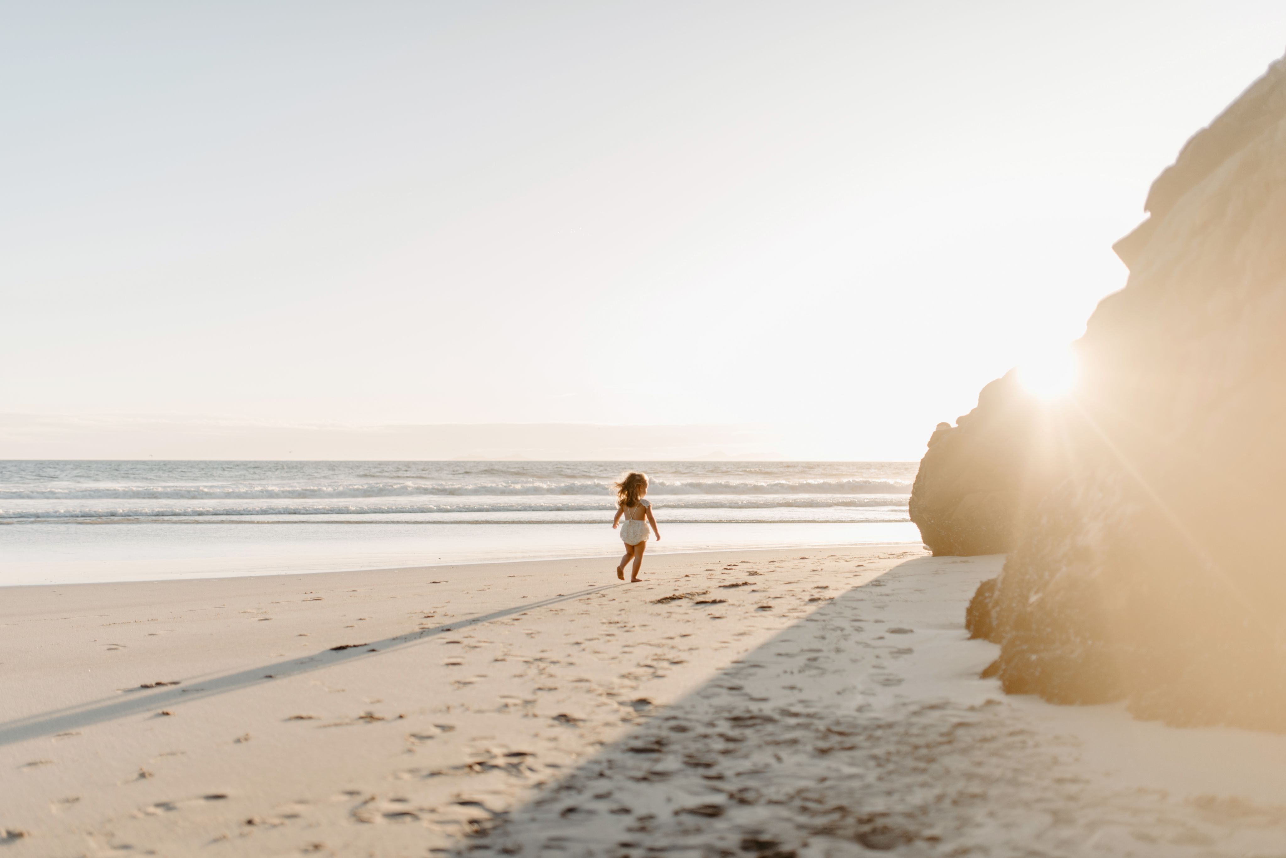 a person toddler  on the beach at sunrise