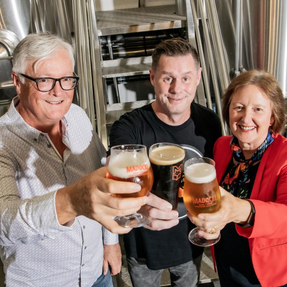 Three people holding beers