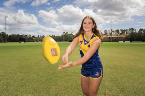 AFL Womens player handballing 