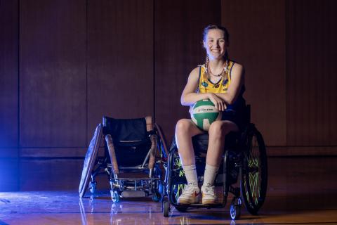 A woman in a wheelchair with a ball in her lap