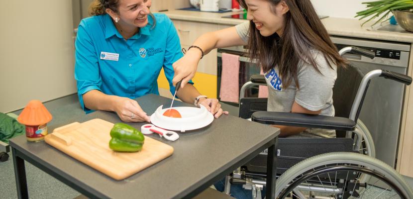 Bond University occupational therapy student sitting with a female in a wheelchair.