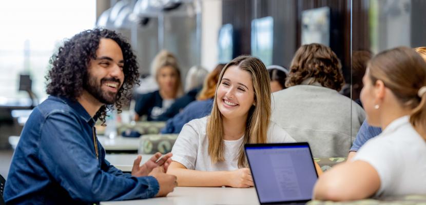 Three students interacting in the library