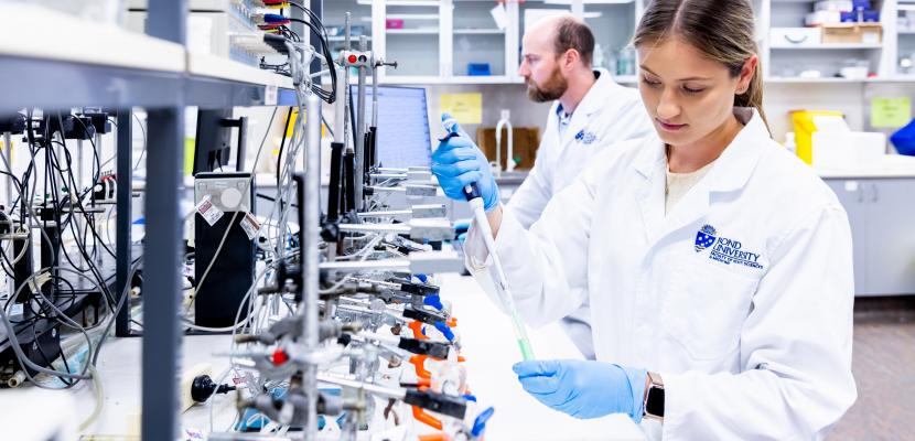 A female student uses a pipette and test tube in a Bond Unviersity Health Sciences & Medicine research laboratory.