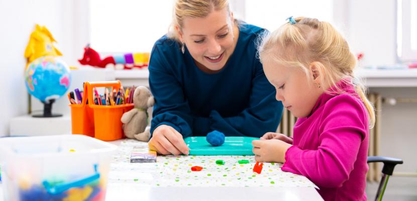 A woman and child play with lego together 