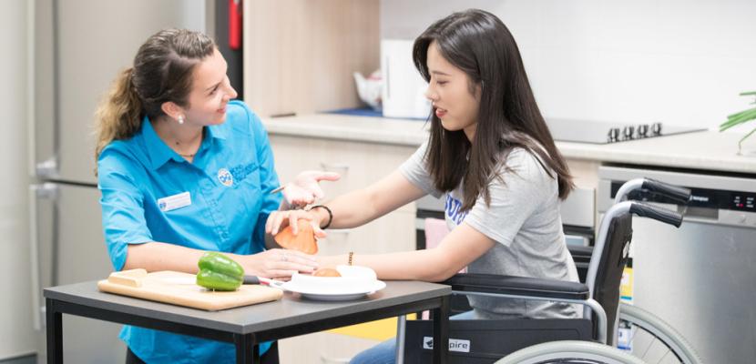 Bond University occupational therapy student sitting with a female in a wheelchair.