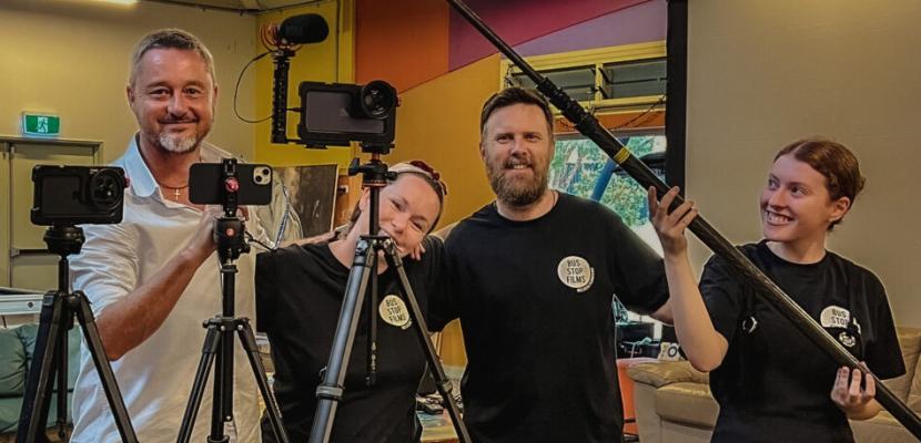 Rob Layton is pictured with three other crew members on Child Boss. They are standing behind iPhones on tripods. One is holding a boom mic.