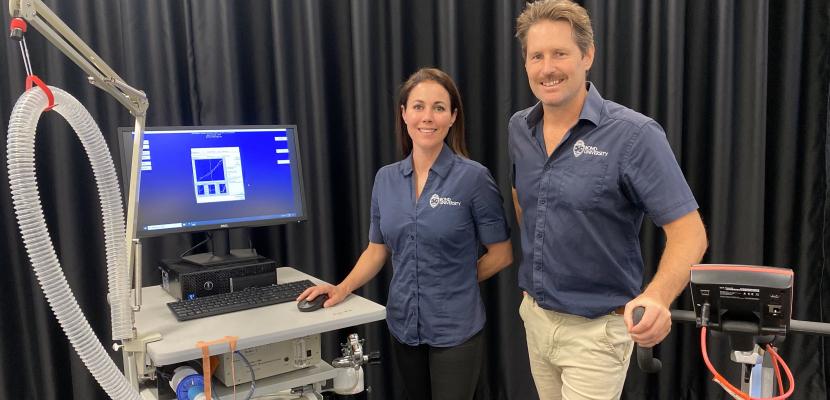 Jacqueline Boundy and Kristin Bower smile in a sports and exercise science lab in front of equipment