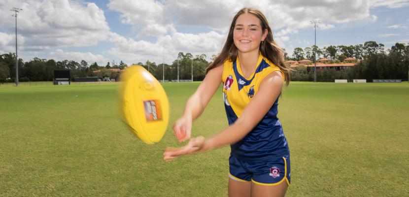 AFL Womens player handballing 