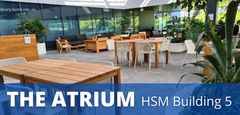 Tables and chairs in a large open area with indoor plants