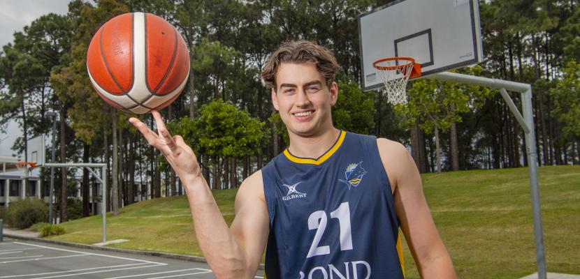 A male Bond basketball player spinning a basketball on his finger