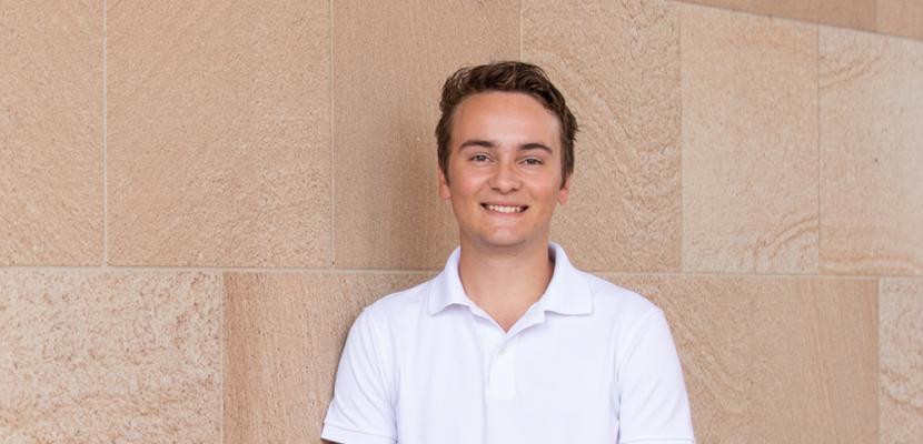 New Columbo Scholarship recipient standing against Arch brickwork for a photo